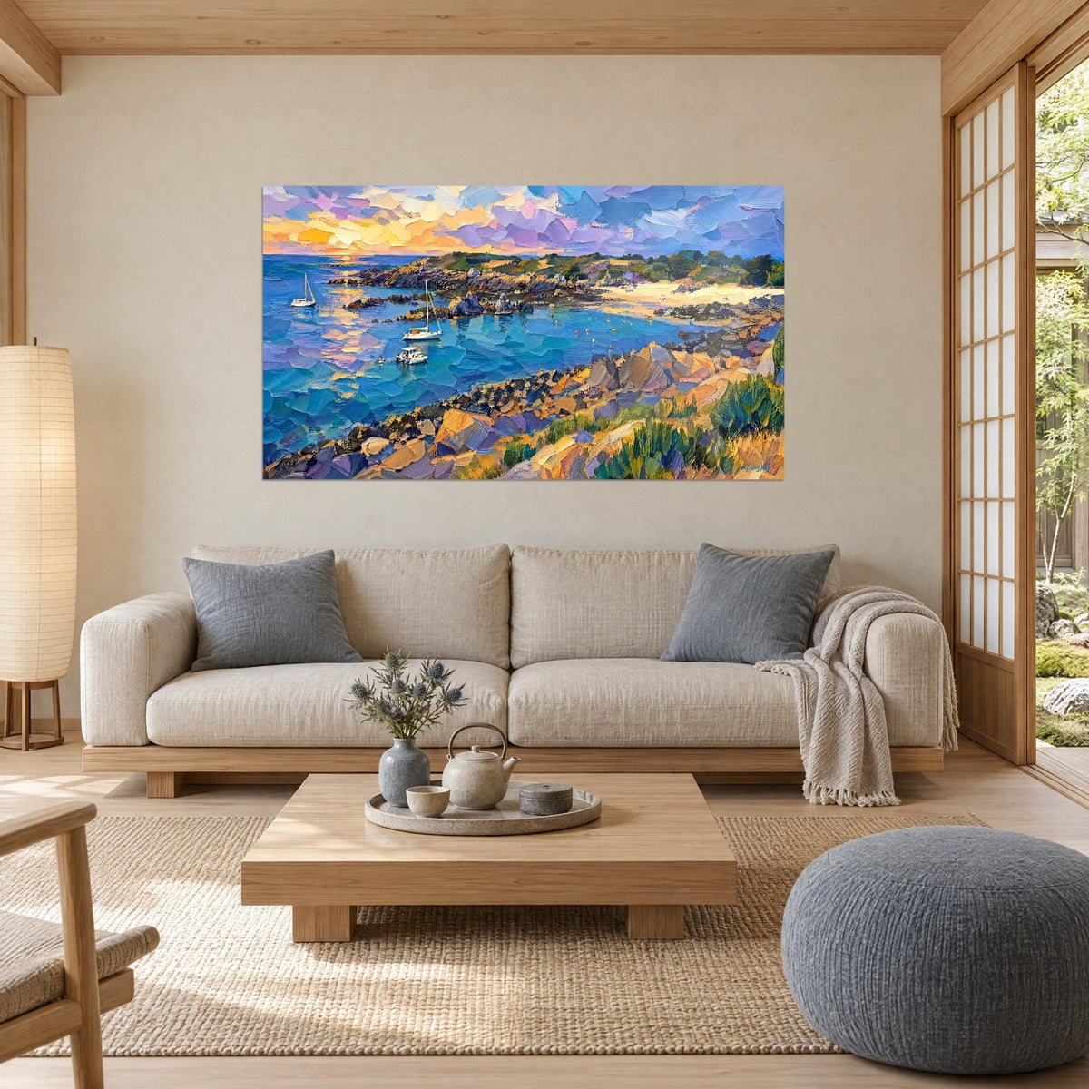 Wall art of a turquoise cove with ochre rocks and moored sailboats, mauve and orange sky, above a sofa in a bright living room