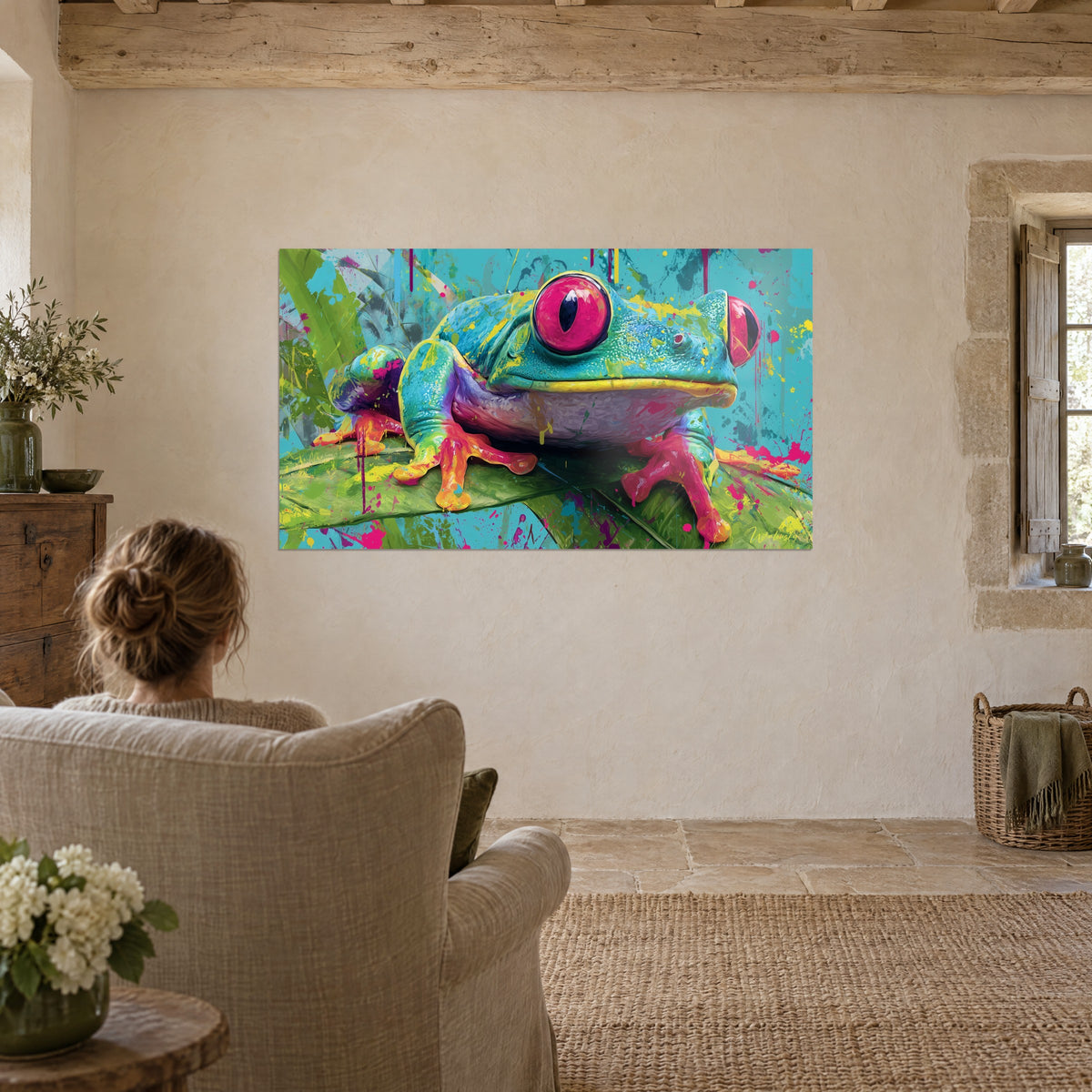 Tableau grenouille aux yeux magenta sur feuille verte, dos turquoise éclaboussé de jaune, face à un fauteuil en lin crème