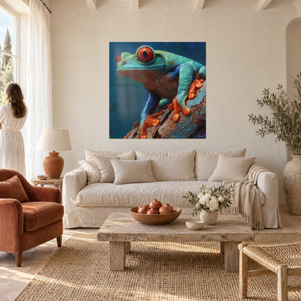 Schilderij groene boomkikker met rode ogen, zich vastklampend aan een tak met oranje tenen, twee personen van achteren, boven een bank in een lichte woonkamer