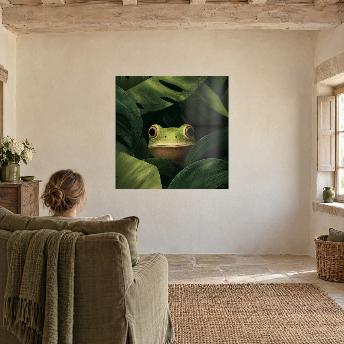 Schilderij nieuwsgierige kikker met bruine buik, omgeven door donkergroene monsterabladeren, een kakikleurige fauteuil en een vrouw van achteren
