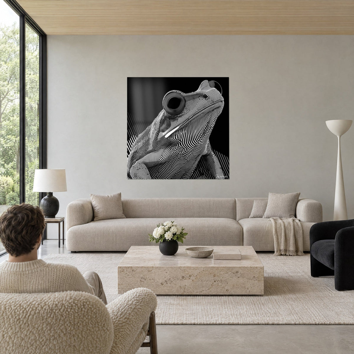 Gemälde Hypnotischer Frosch mit schwarz-weißen Streifen, runde spiralförmige Augen auf schwarzem Hintergrund, über einem Sofa in einem hellen Wohnzimmer
