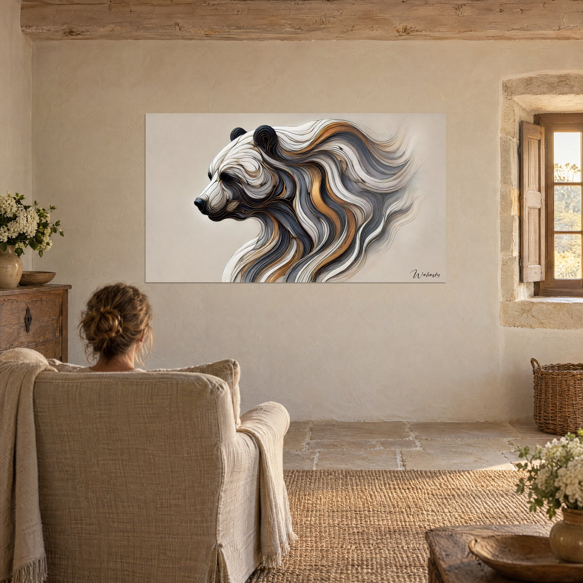 Wall art big cat in sinuous off-white, bronze and charcoal flows, admired by a woman seen from behind in a beige linen armchair