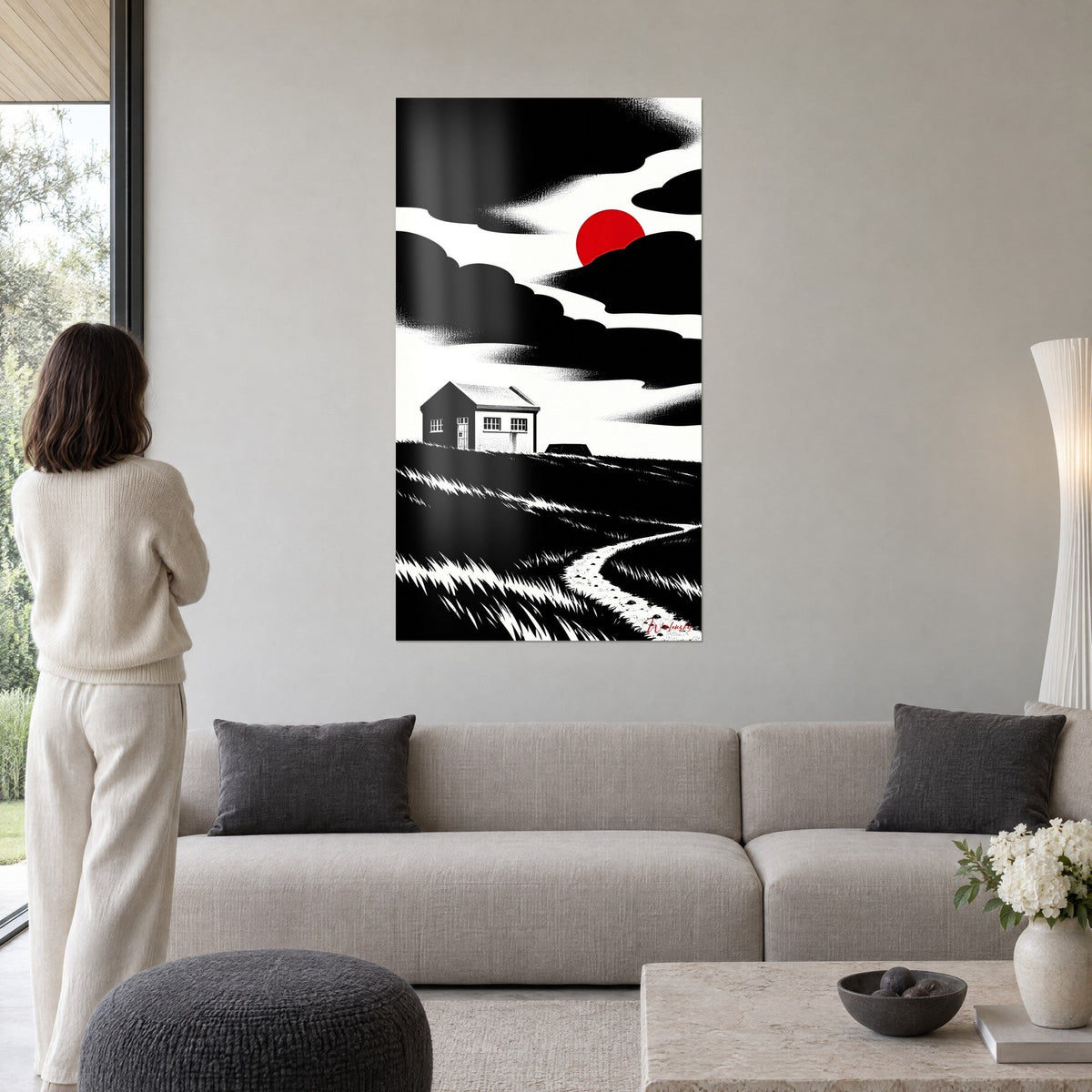 Quadro casetta bianca sotto un sole rosso, nuvole nere dense ed erba tratteggiata, sopra un divano in un soggiorno luminoso