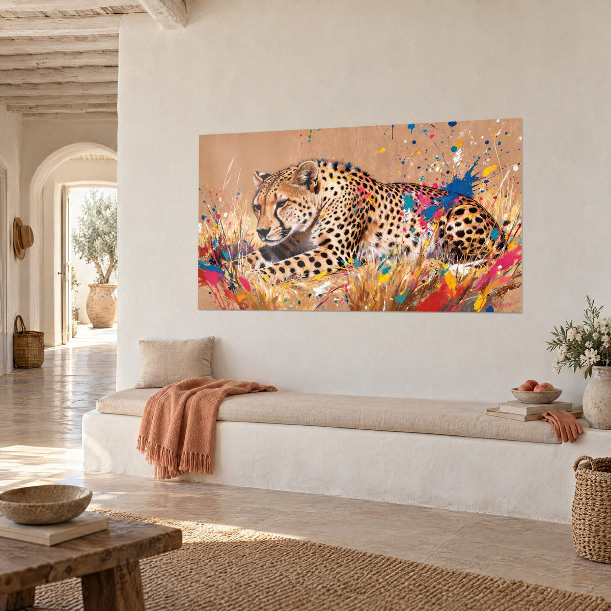 Cuadro felino moteado de mirada atenta, fondo beige arena y salpicaduras de pintura roja y turquesa, banco blanco mediterráneo