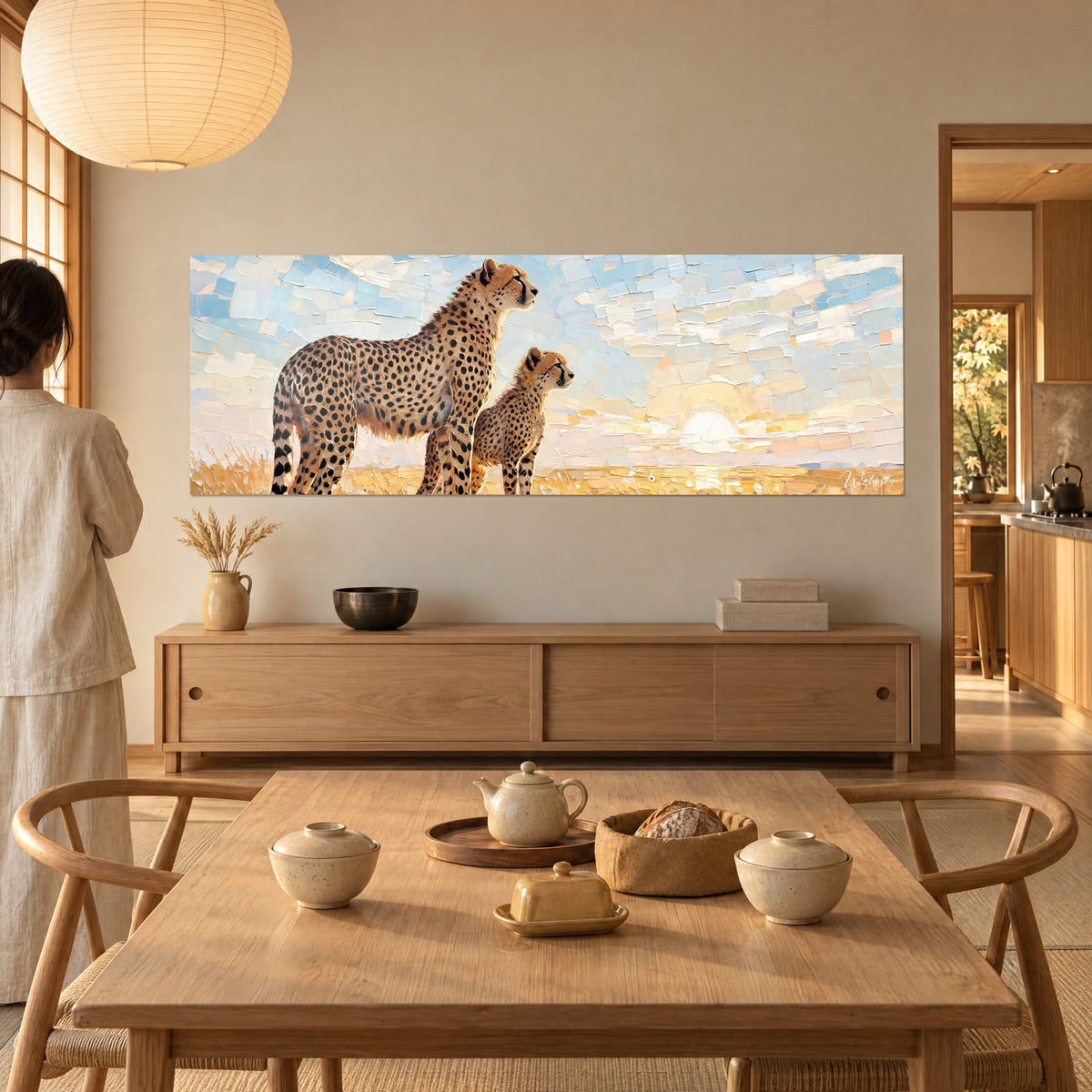 Wall art two savannah cats at morning rest, black spots on ochre and pastel blue background, woman seen from behind beside a wooden dining table