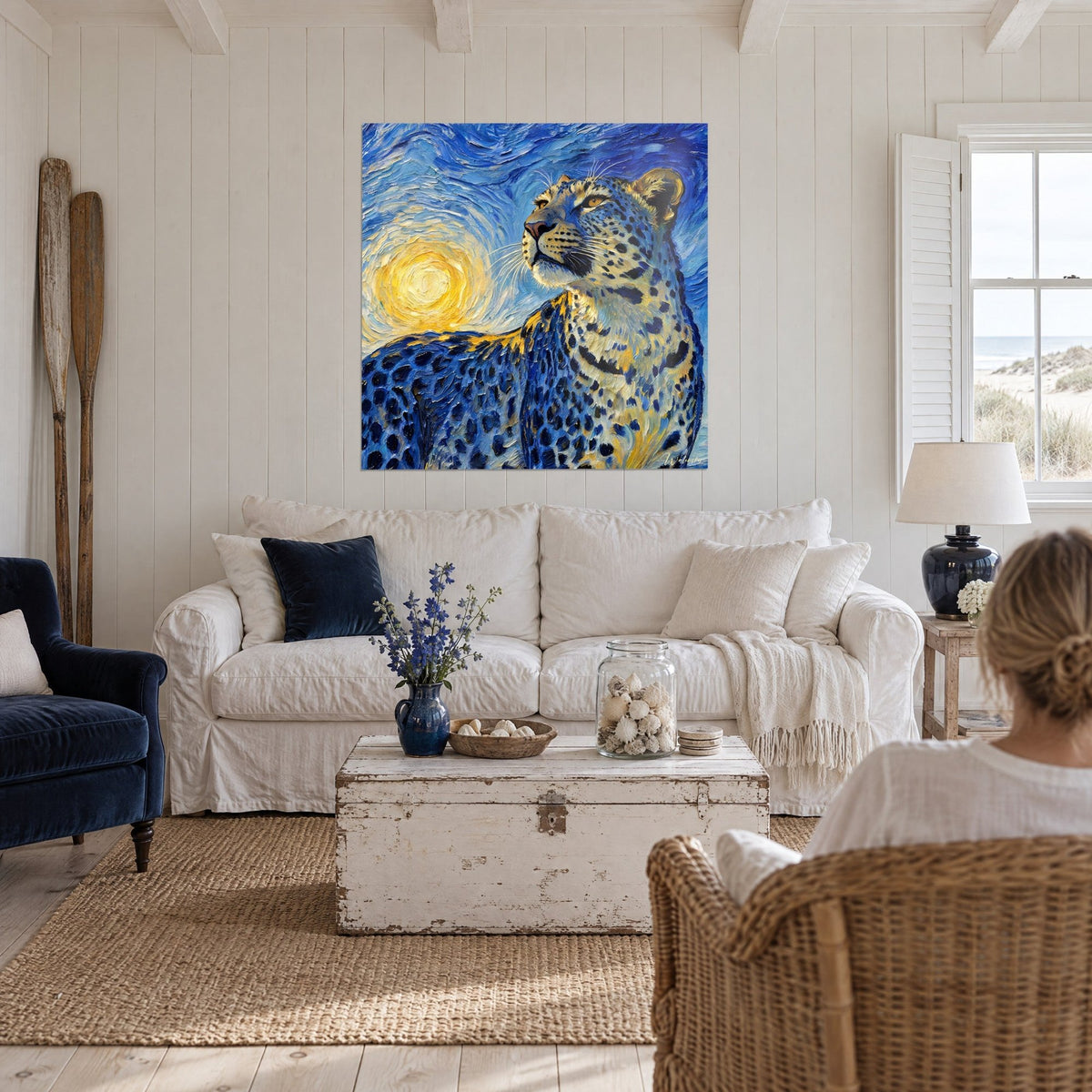 Tableau fauve moucheté levant le museau vers un soleil jaune tourbillonnant, bleu cobalt et or, au-dessus d'un canapé dans un salon lumineux