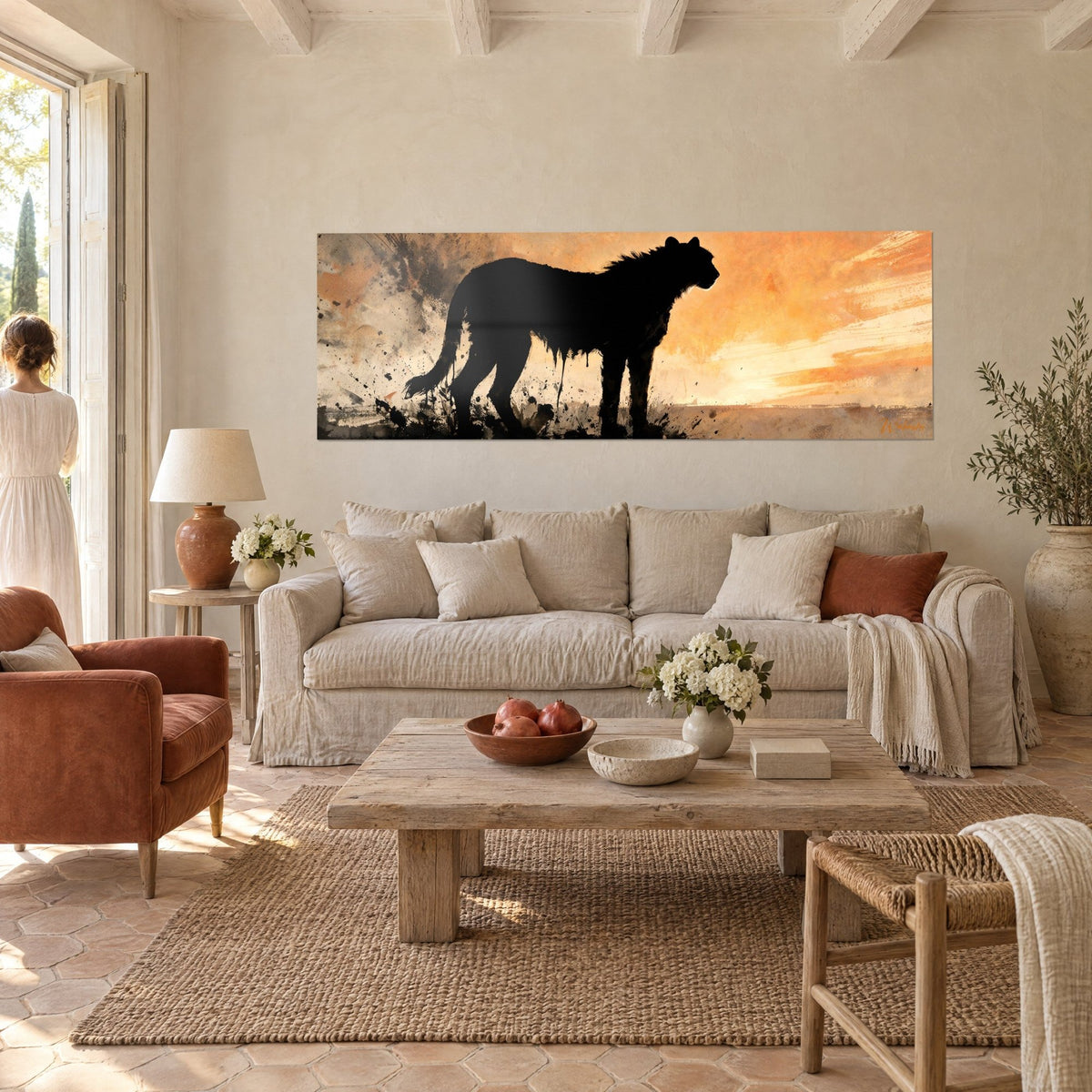 Tableau félin noir à la crinière hirsute sur ciel orange et ocre, une femme de dos, au-dessus d'un canapé dans un salon lumineux