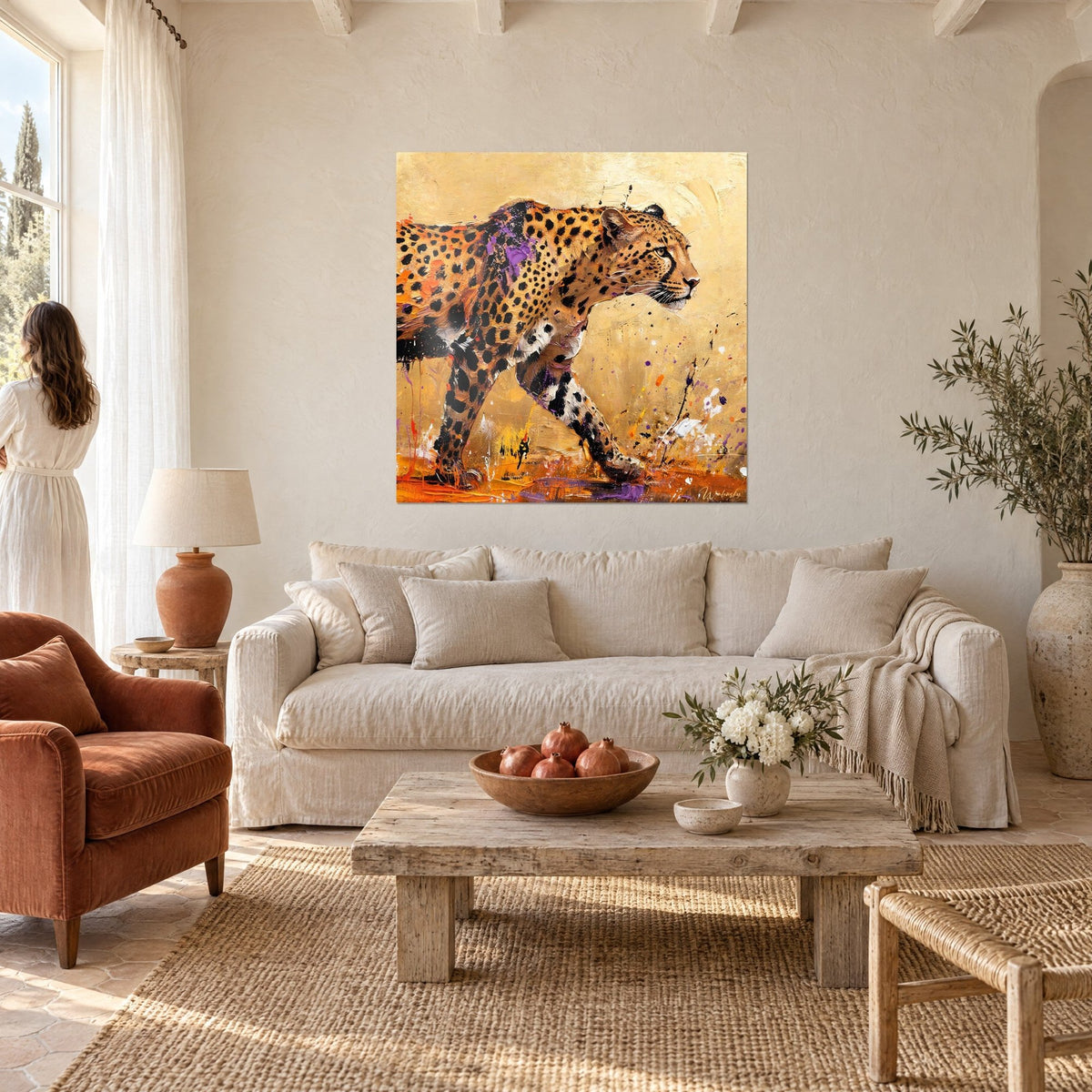 Wall art of a spotted big cat on the move, golden coat with violet touches, sandy background, woman seen from behind above a sofa in a bright living room