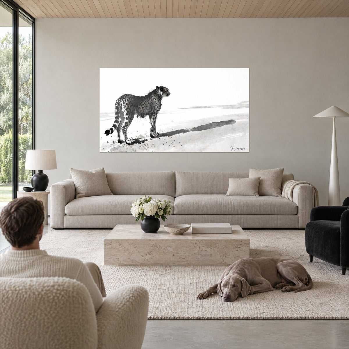 Wall art cheetah in black ink, stretched shadow on white sand, above a sofa in a bright living room