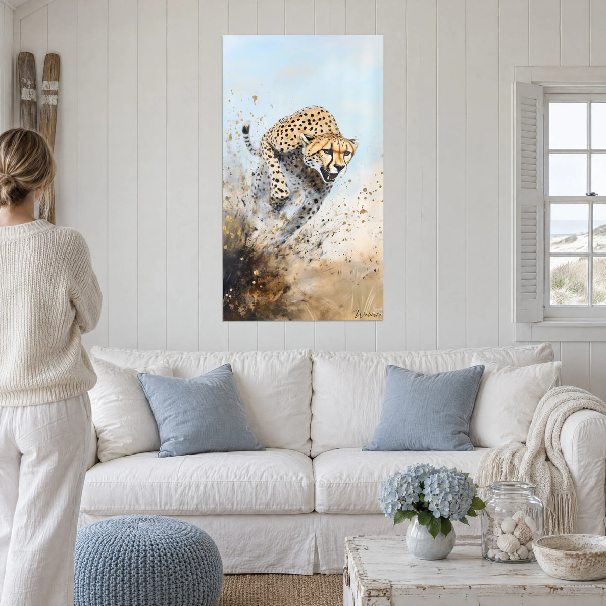 Cuadro de un felino moteado saltando, pelaje ocre y cielo azul pálido, salpicaduras doradas, sobre un sofá en un salón luminoso