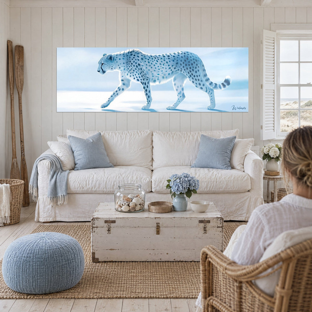 Cuadro guepardo blanco escarchado con manchas azul acero, pelaje claro sobre hielo, encima de un sofá en un salón luminoso