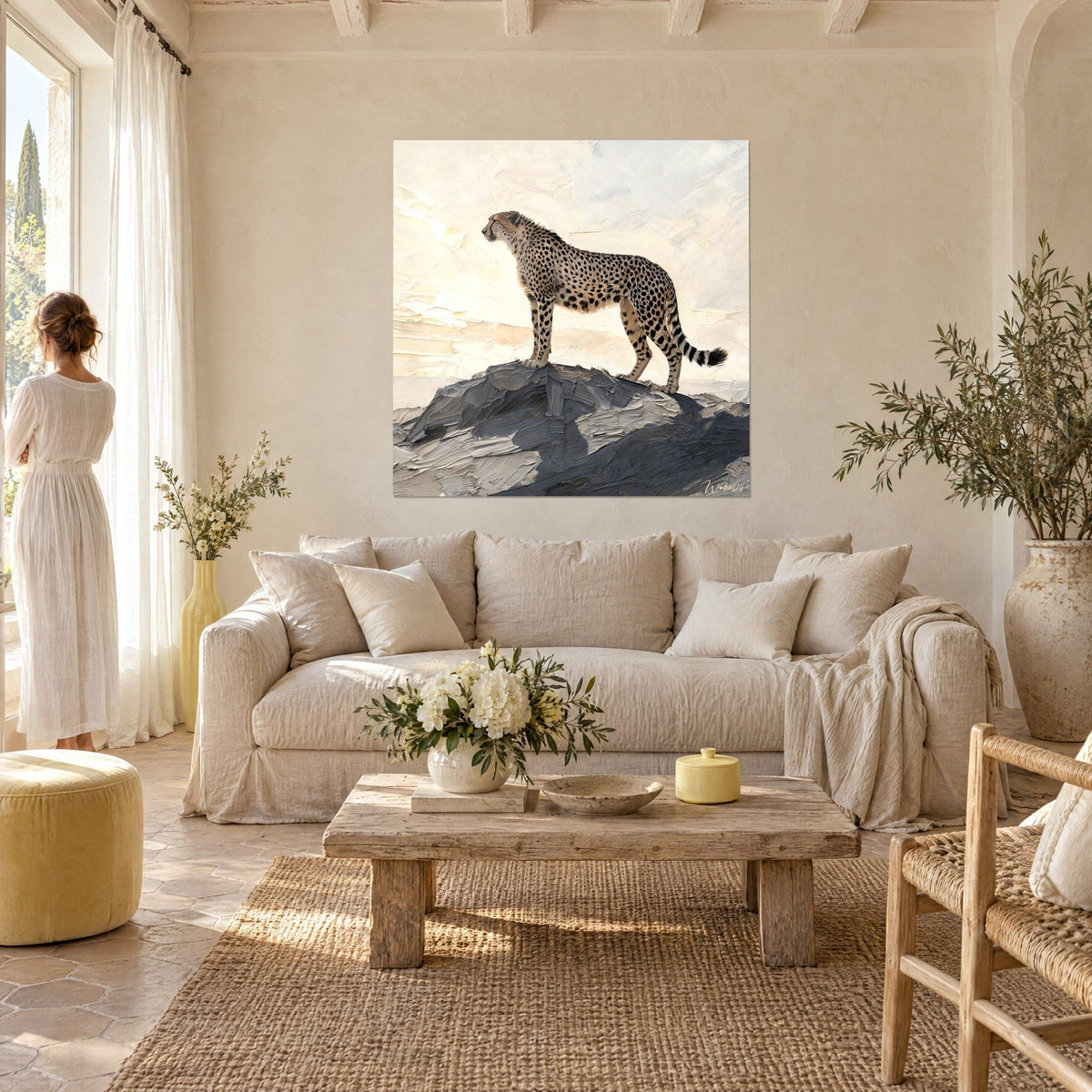 Gemälde Gepard auf anthrazitfarbenem Felsen stehend, cremefarbener Himmel mit pastosem Farbauftrag, Person von hinten über einem Sofa in einem hellen Wohnzimmer