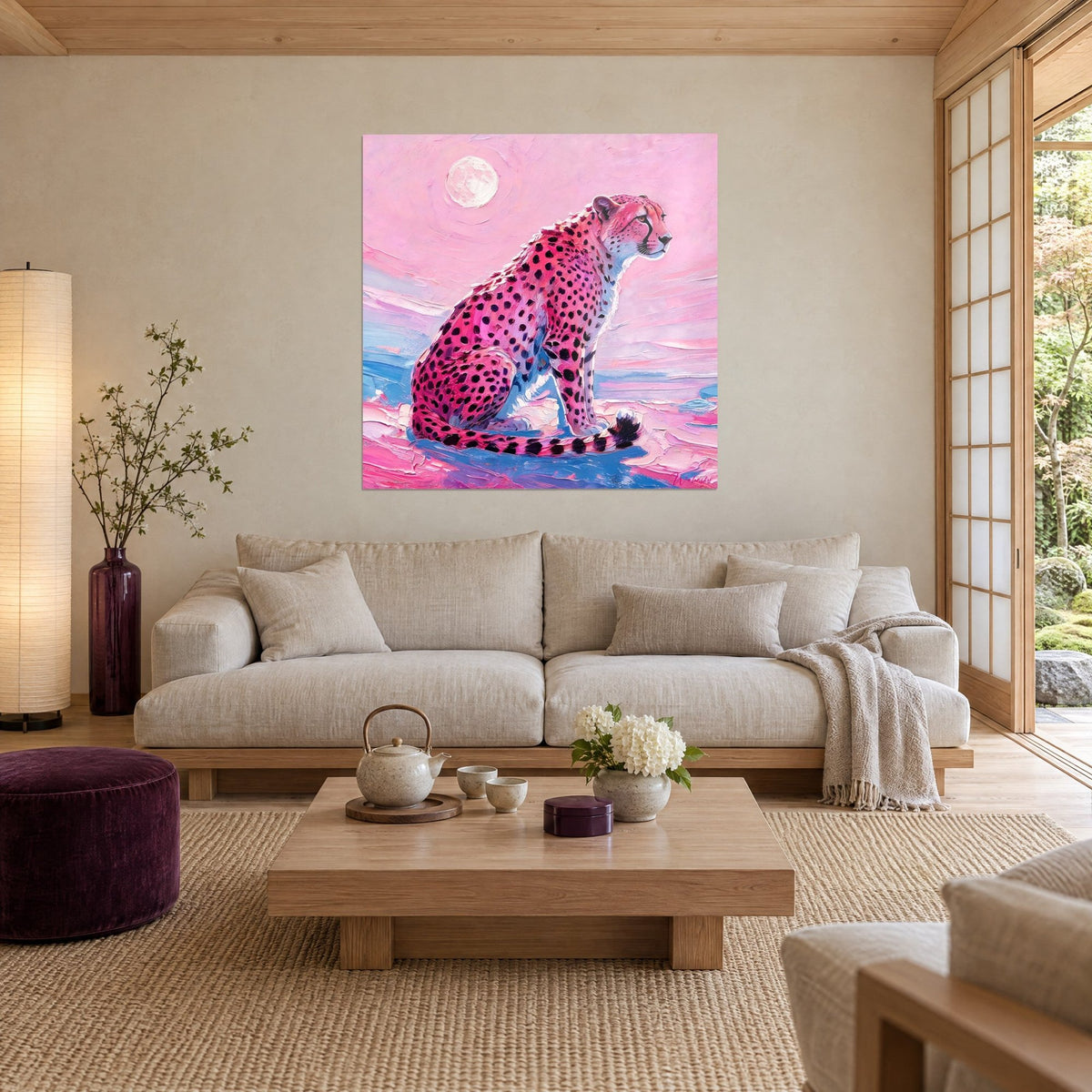 Gemälde Gepard rosa sitzend, schwarz gefleckter Pelz, elfenbeinfarbener Mond und blaues Meer, über einem Sofa in einem hellen Wohnzimmer