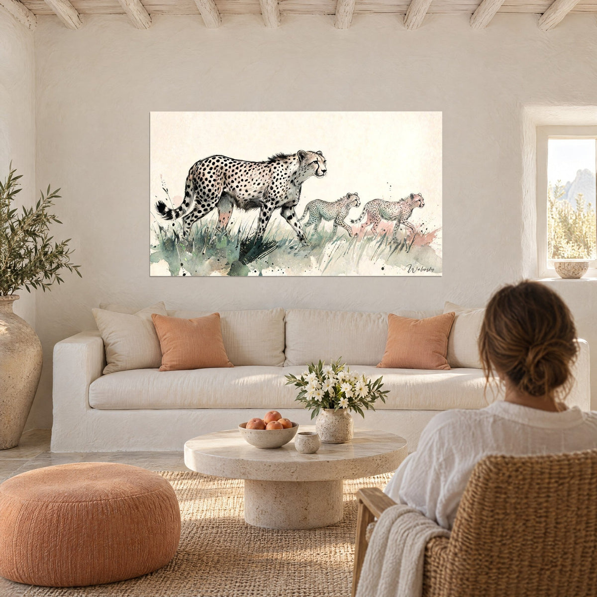 Tableau guépard et ses deux petits en aquarelle ivoire et vert sauge, taches noires, au-dessus d'un canapé dans un salon lumineux