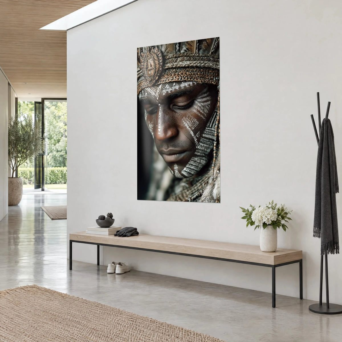 Schilderij van een tribaal portret in close-up, ivoorkleurige krijtmotieven op koperkleurige huid, beige veren, aan een witte muur naast een houten bank