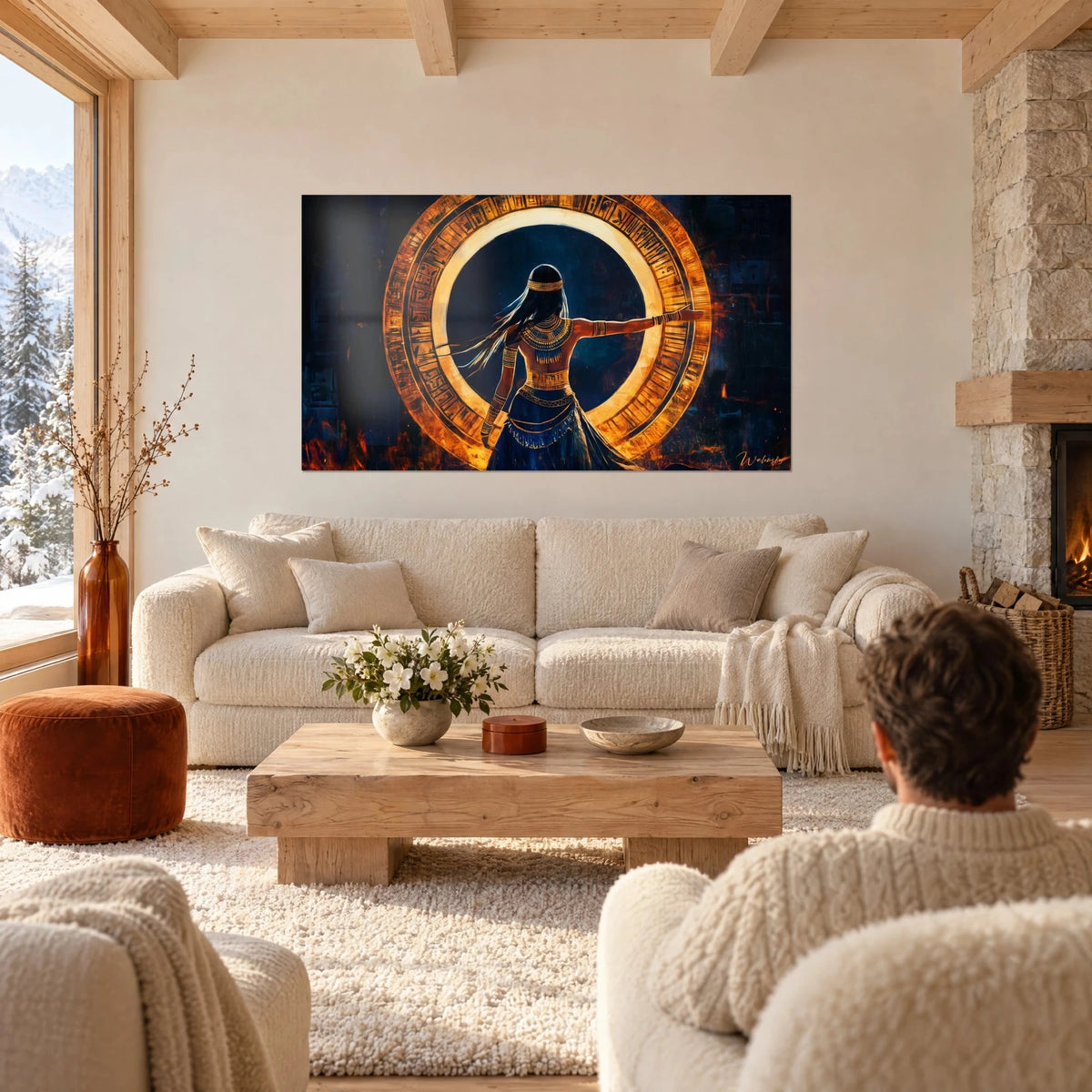 Quadro di una danzatrice egizia di spalle, braccio teso davanti a un anello di geroglifici arancio e oro su fondo blu notte, sopra un divano in un soggiorno luminoso