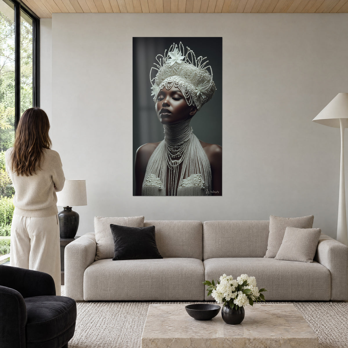 Cuadro retrato de una mujer de piel de ébano, tocado de perlas marfil y flores blancas, fondo gris oscuro, encima de un sofá en un salón luminoso