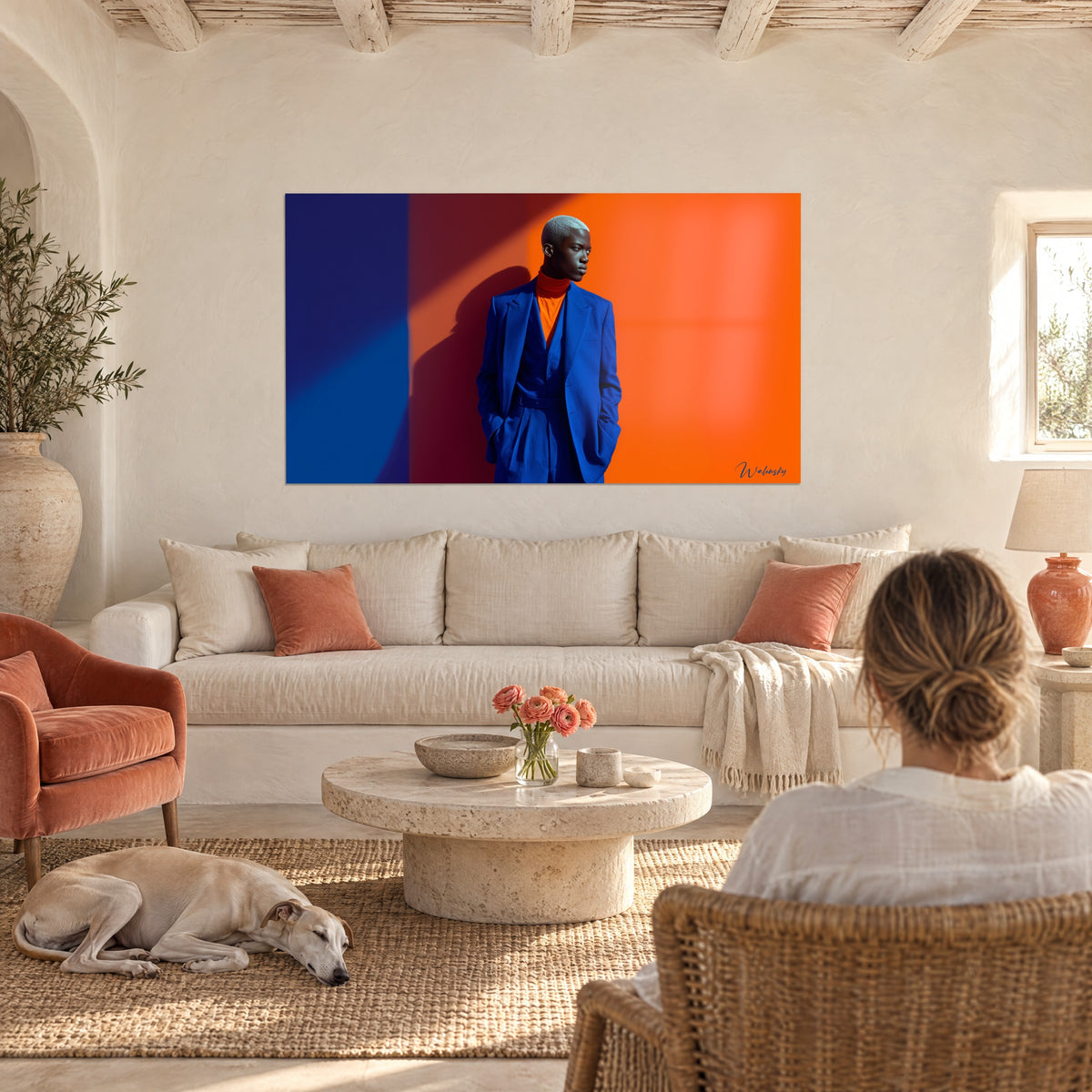 Wall art silver-skulled mannequin in royal blue suit, orange background and drop shadow, above a sofa in a bright living room