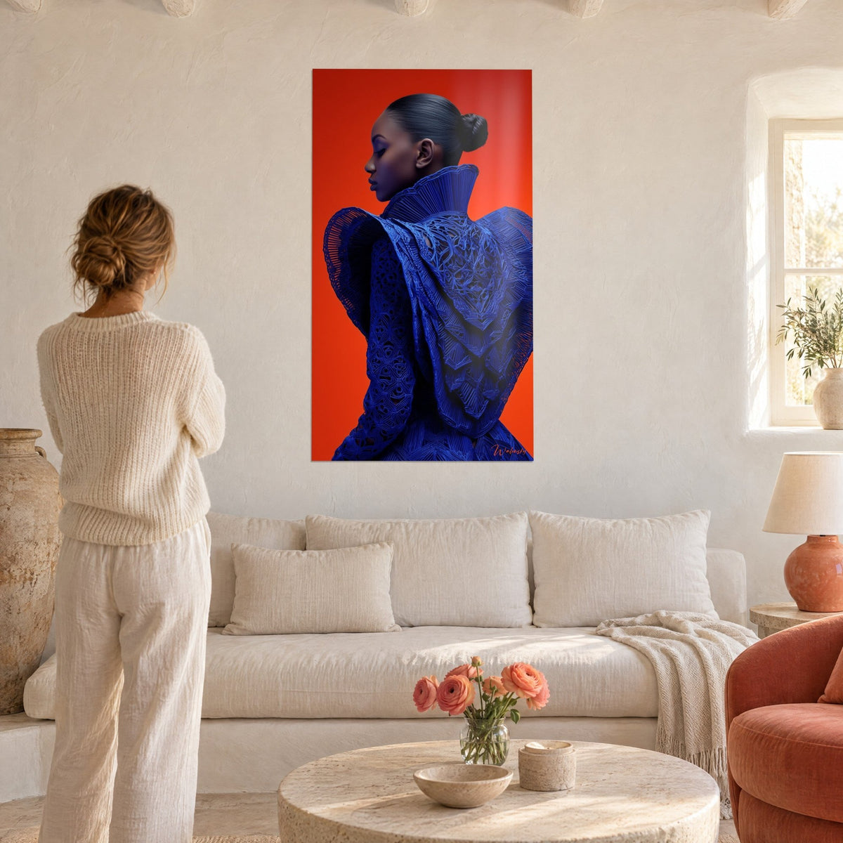 Quadro silhouette in abito traforato blu reale, profilo su sfondo arancione vivo, donna di spalle sopra un divano in un soggiorno luminoso