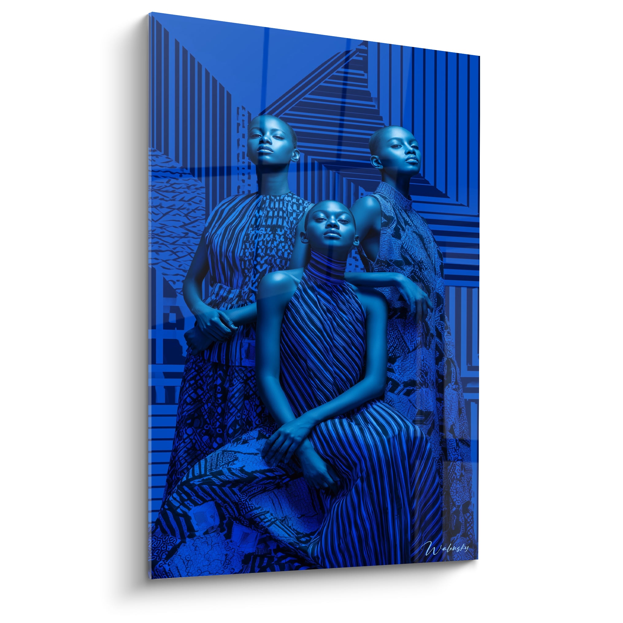 Trois mannequins bleu roi drapés de motifs anthracite, posture hiératique en tableau haute couture