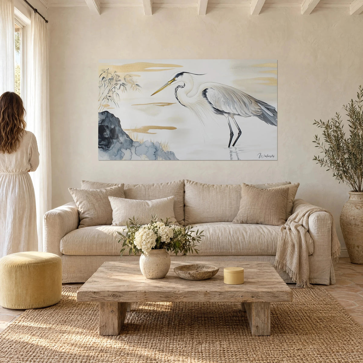 Tableau héron cendré en aquarelle, plumage blanc et gris, nuages dorés, rocher bleu-noir, au-dessus d'un canapé dans un salon lumineux