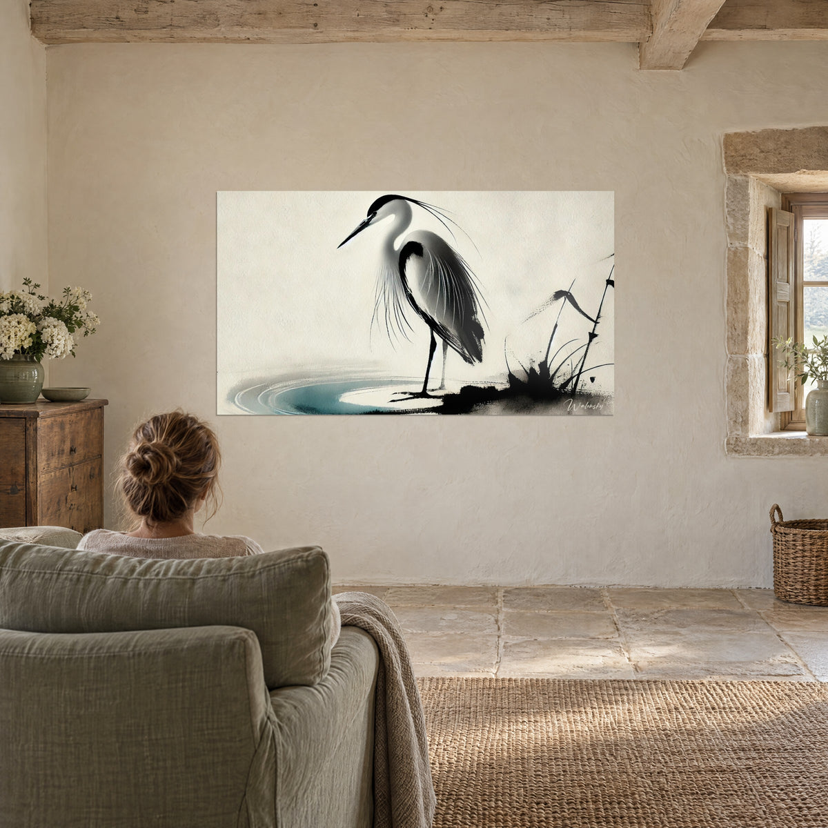 Tableau héron immobile au bord d'un étang, encre noire et touche turquoise sur fond sable, face à un fauteuil vert sauge