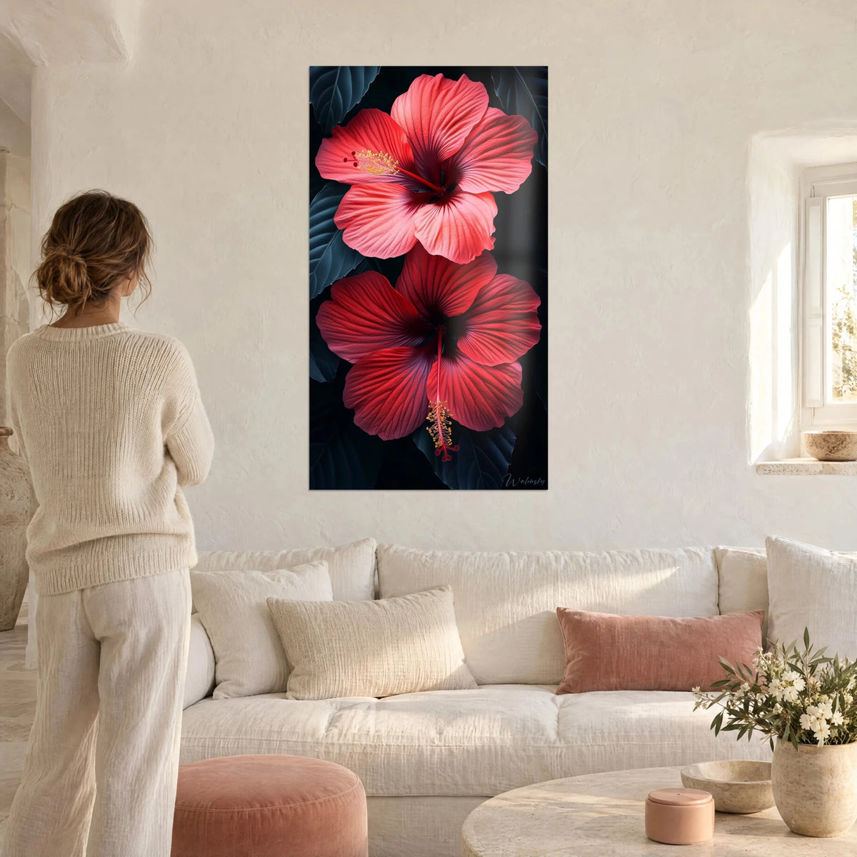 Cuadro hibisco rojo coral de pétalos venados, corazón púrpura sobre follaje oscuro, encima de un sofá en un salón luminoso