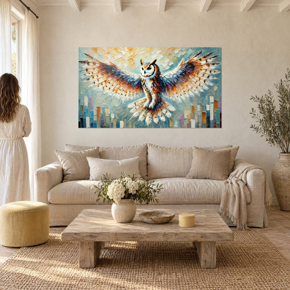 Gemälde Eule mit ausgebreiteten Flügeln, schieferblaue und ockerfarbene Federn, bernsteinfarbener Blick, Paar von hinten über einem Sofa in einem hellen Wohnzimmer