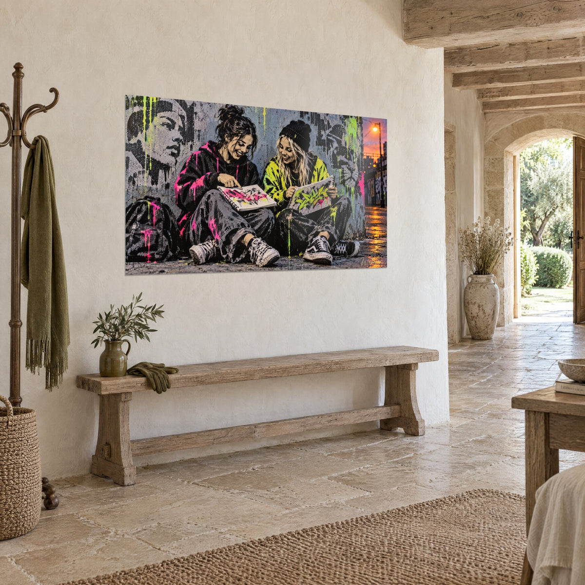 Tableau complicité de deux amies dessinant un tag, hoodie magenta et blouson citron, mur de pierre blanche à poutres