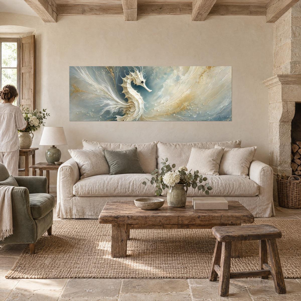 Tableau hippocampe ivoire aux nageoires en plumes, fond bleu-gris et poussière d'or, une femme de dos, au-dessus d'un canapé dans un salon lumineux