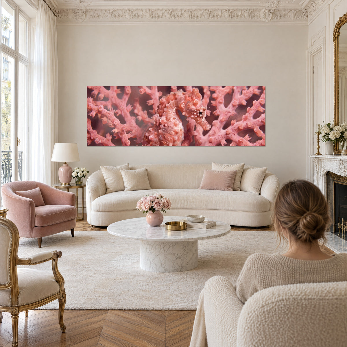 Schilderij van een dwergzeepaardje in koraalroze, genesteld in een zalmkleurige zeewaaier, buisvormige snuit, zwart oog met ring, boven een bank in een lichte woonkamer