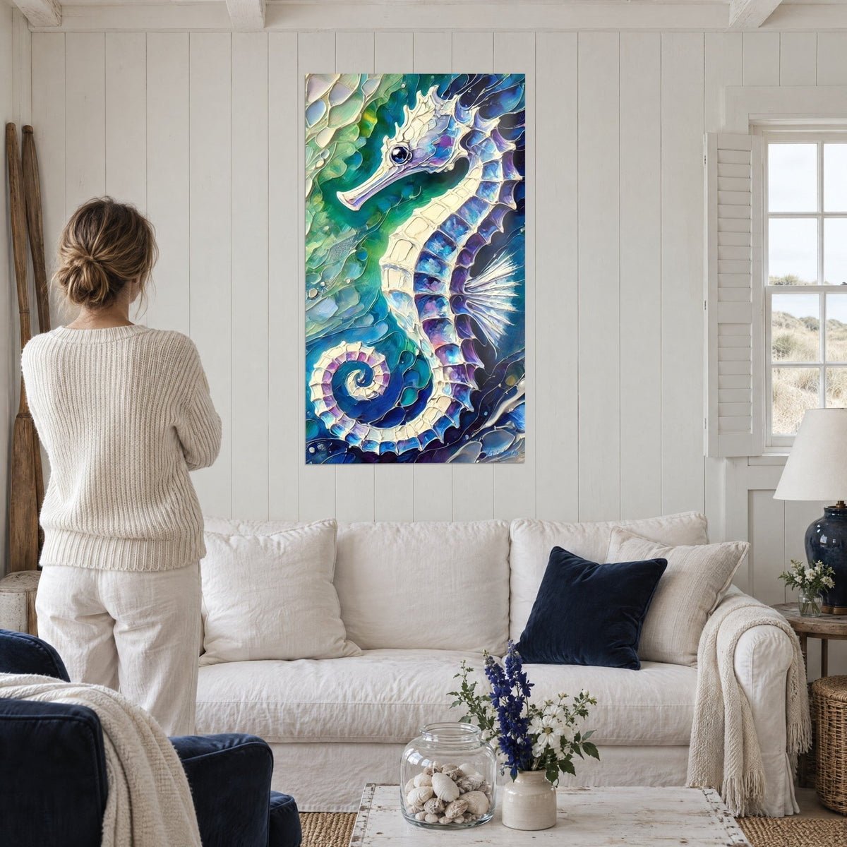 Gemälde Seepferdchen mit perlmuttartigen Schuppen in Blau und Violett, smaragdgrüner Hintergrund, über einem Sofa in einem hellen Wohnzimmer