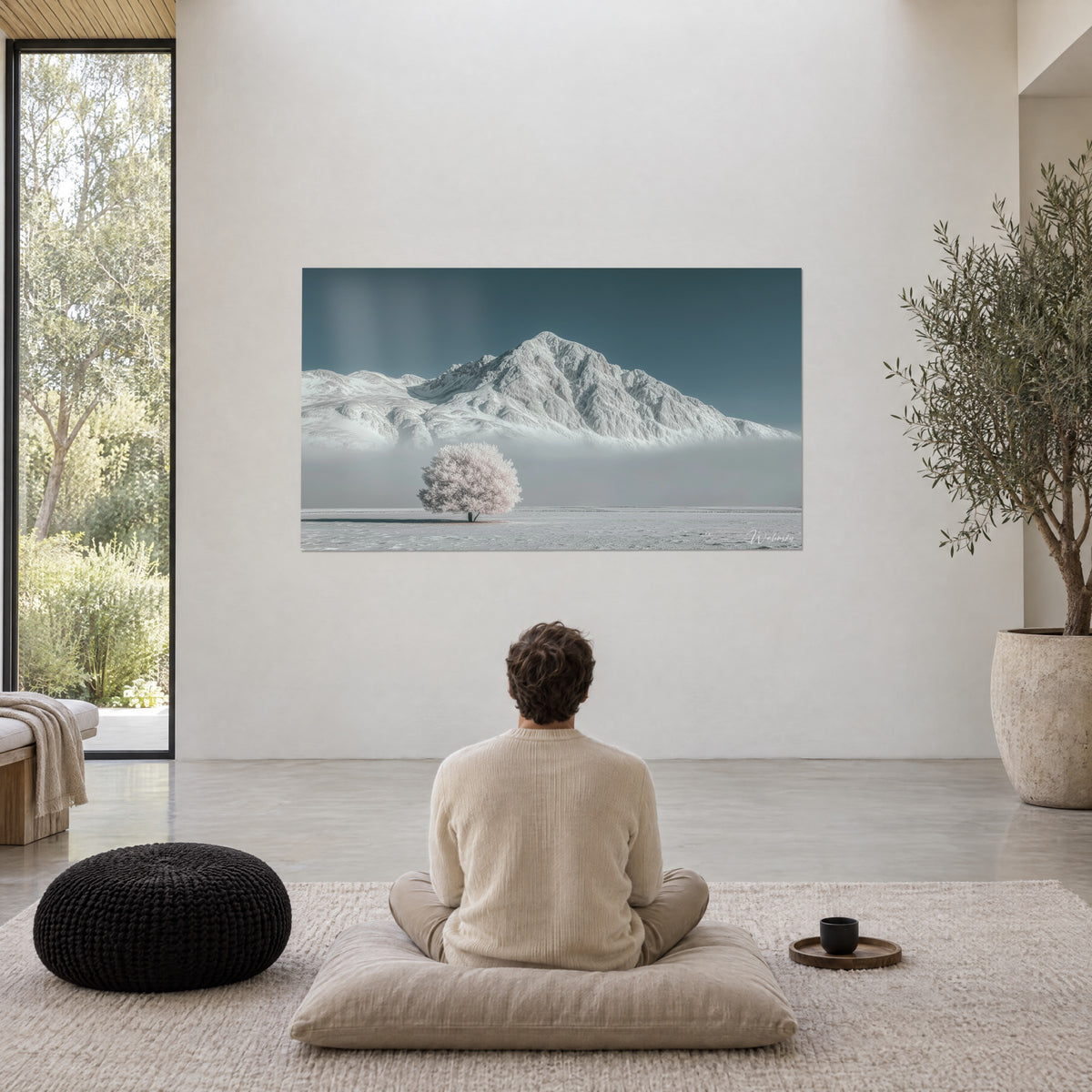 Tableau mont immaculé, arbre de givre rose et nappe de brume grise, contemplé par un homme assis de dos dans un salon épuré