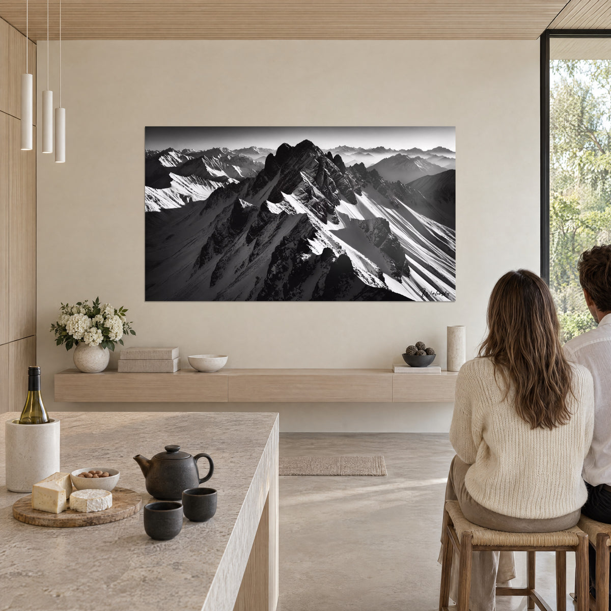 Wall art panorama of snowy peaks, anthracite ridges against a pale mist, two people seen from behind near a kitchen island