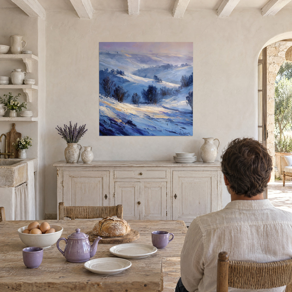 Cuadro hondonada escarchada con arbustos oscuros sobre nieve azul pervinca y oro pálido, frente a una mesa de cocina de madera, mas provenzal