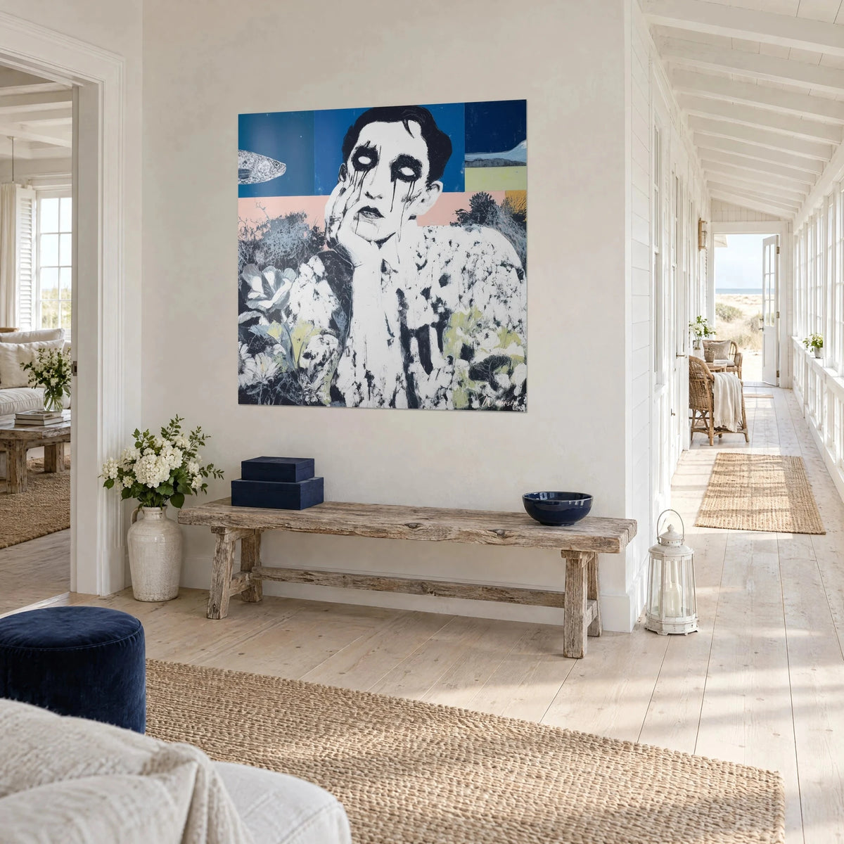 Wall art pallid clown with hollow eyes and hand on cheek, deep blue and chalk white, at the end of a seaside house hallway