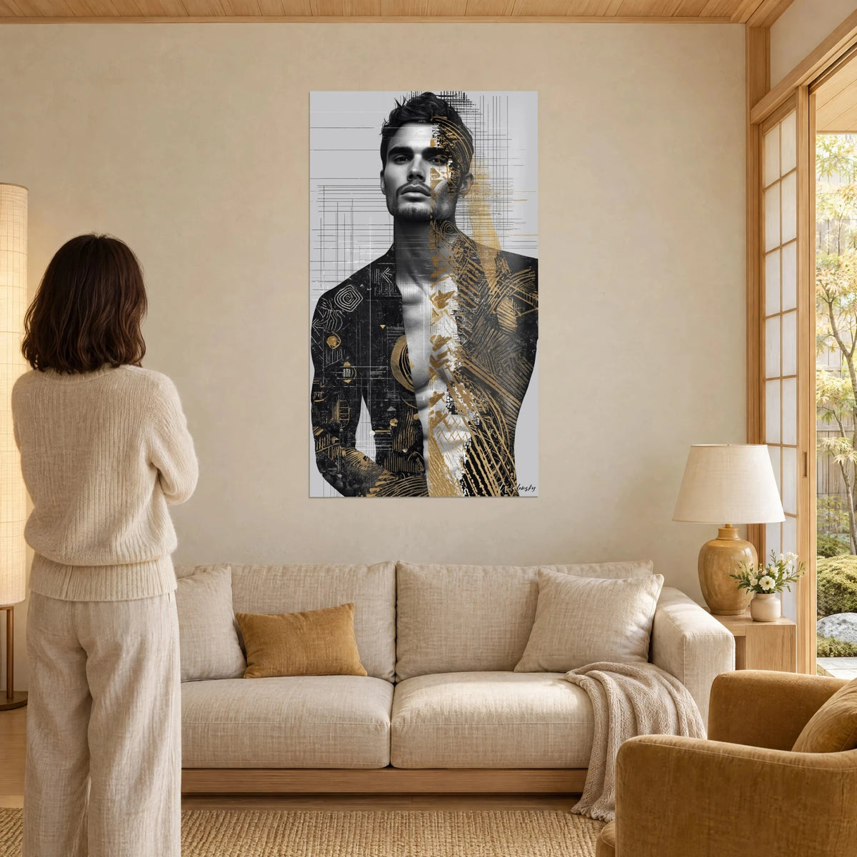 Schilderij portret van een man met frontale blik, zwarte jas en okergouden motieven, grijze achtergrond, vrouw van achteren, boven een bank in een lichte woonkamer