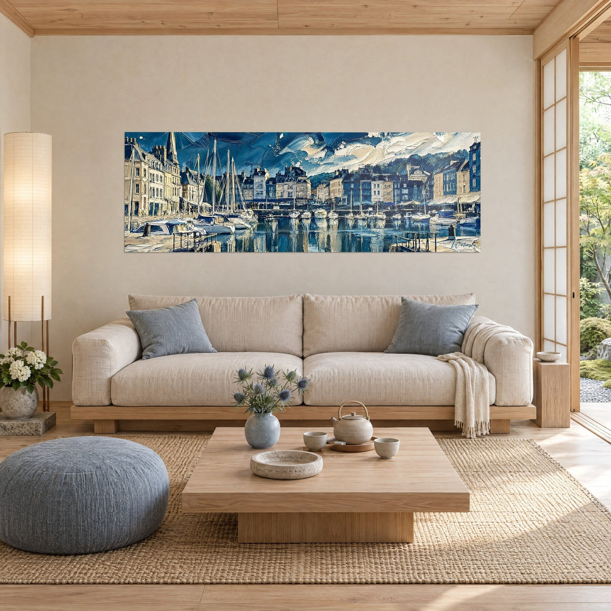 Wall art of the old port of Honfleur with ochre facades and white sailboats, deep night-blue sky in thick impasto, above a sofa in a bright living room
