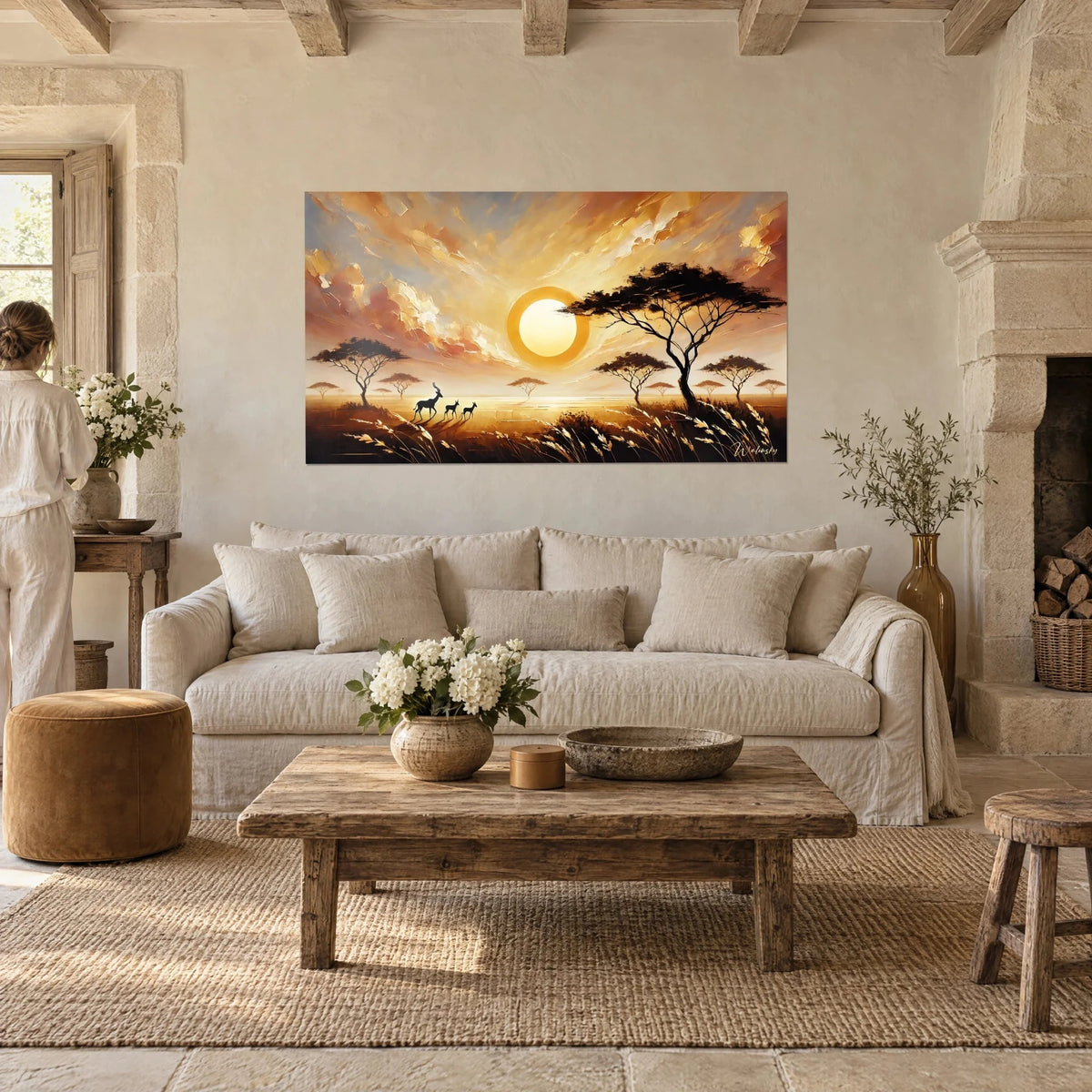 Wall art golden sun over the savanna, black acacias and a sky of ochre and pink, seen from behind above a sofa in a bright living room