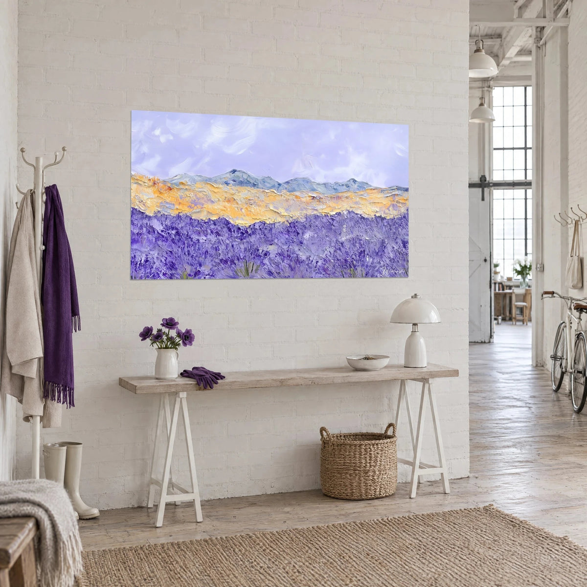 Cuadro horizonte de colinas azuladas bajo un cielo lavanda, bandas ocre gruesas, visto en tres cuartos sobre una consola de madera