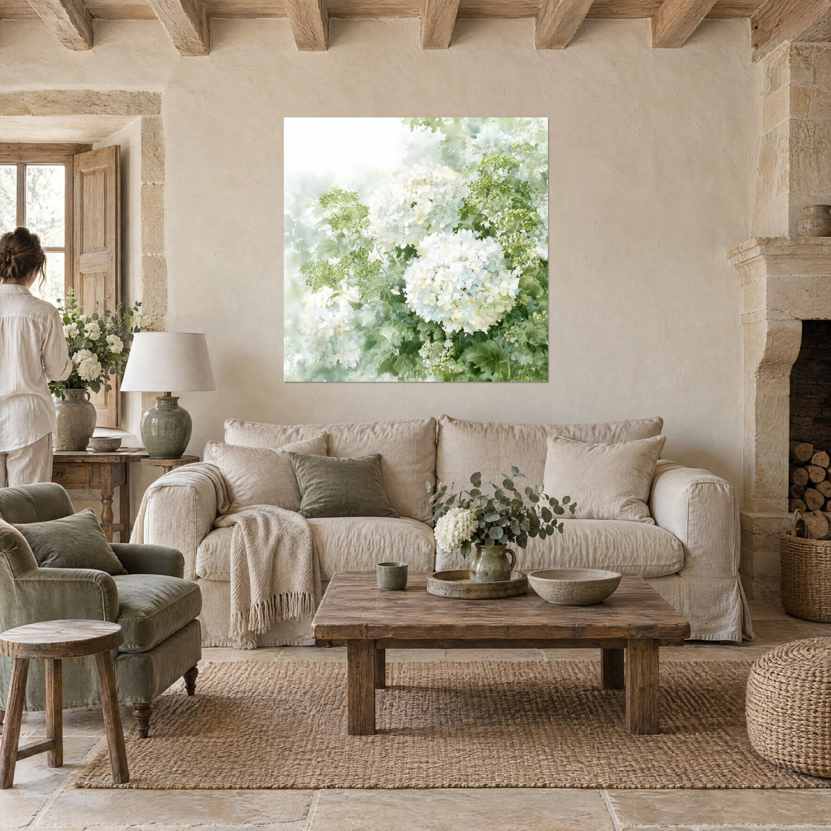 Wall art of white hydrangeas in large cream clusters, soft green foliage and mist, above a sofa in a bright living room
