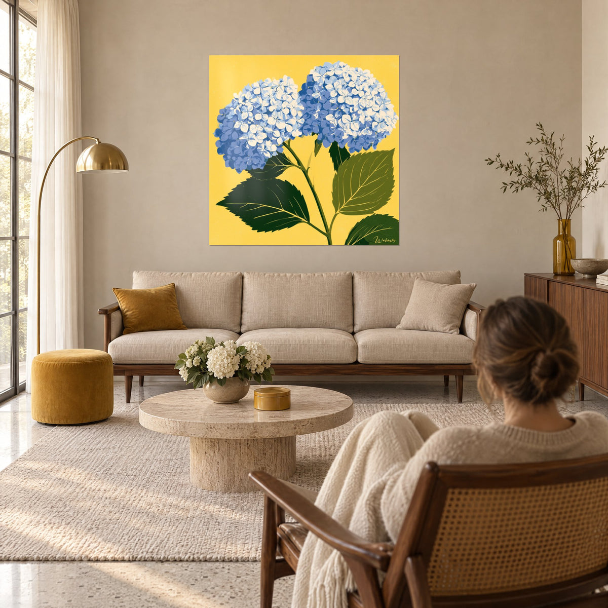Wall art blue hydrangeas with cream petals, fir green leaves on a sunny yellow background, above a sofa in a bright living room