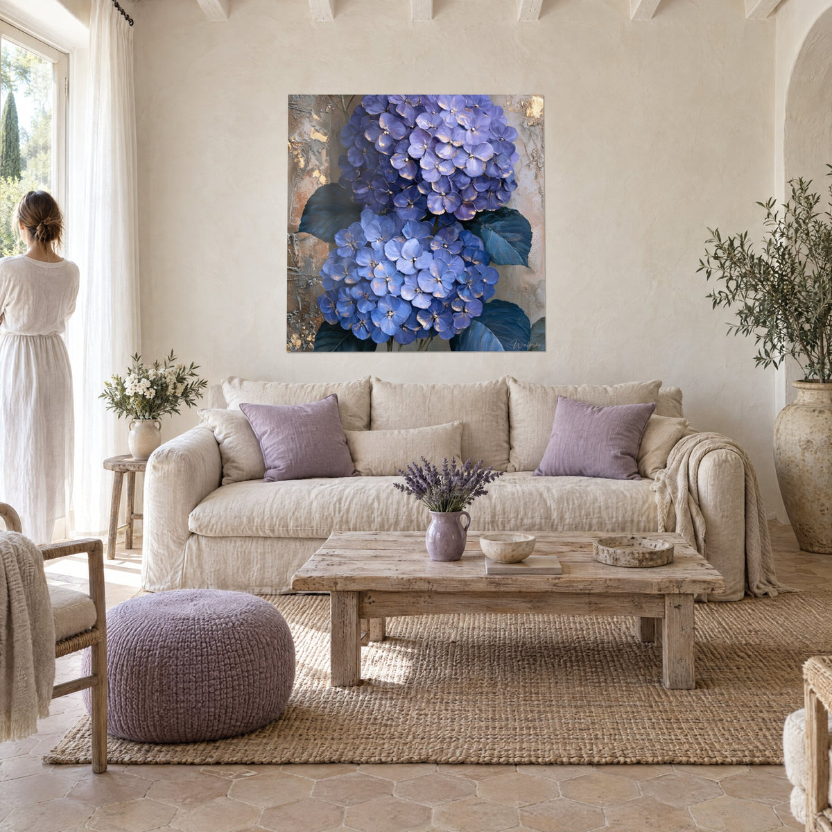 Quadro di ortensie blu cobalto e lavanda con riflessi dorati, pittura spessa e materica, sopra un divano in un soggiorno luminoso