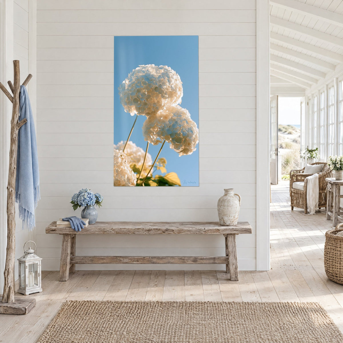 Wall art of cream and pale blue hydrangea clusters, fine stems and yellow leaves, three-quarter view, beach house