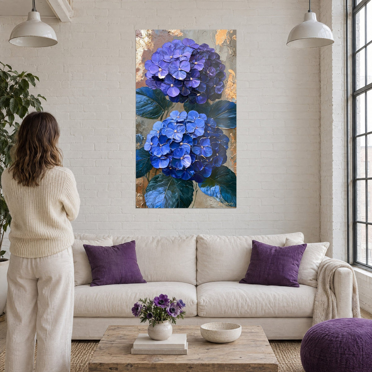 Gemälde violette und blaue Hortensien in dicker Pastenmalerei, dunkelgrüne Blätter, goldocker Hintergrund, über einem Sofa in einem hellen Wohnzimmer