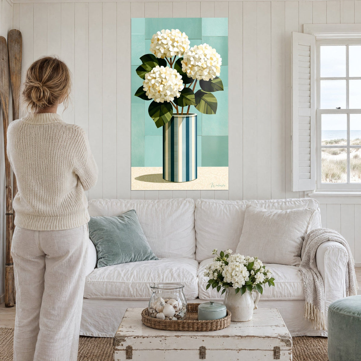 Wall art cream hydrangeas in three full clusters, fir-green leaves, turquoise background, above a sofa in a bright living room
