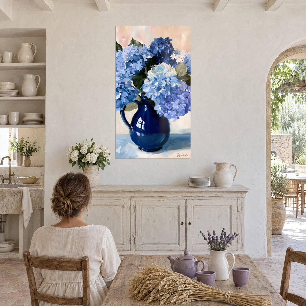 Cuadro de racimos de hortensias azul periwinkle y crema, reflejos en la jarra azul marino, frente a una mujer sentada a una mesa junto a un arco