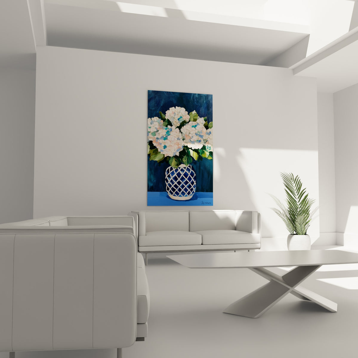 Fleurs d'hortensias roses et blanches en vase bleu marine texturé, au-dessus d'un canapé dans un salon lumineux