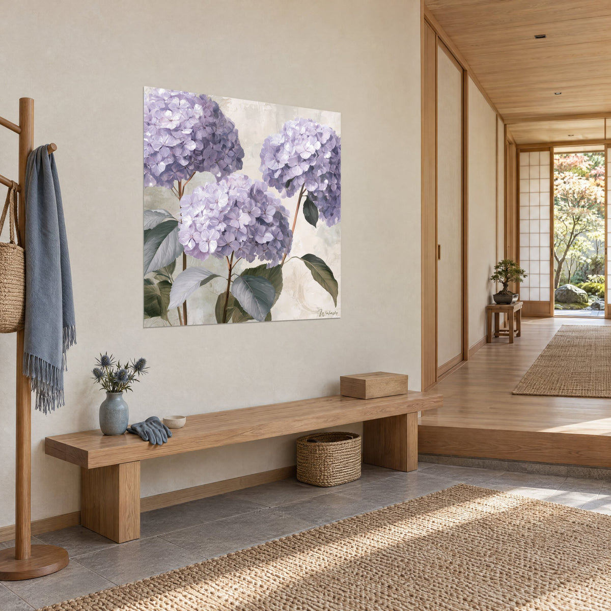 Quadro con tre sfere di fiori lilla e lavanda, fogliame verde grigio su fondo beige, in un ingresso japandi illuminato dal sole