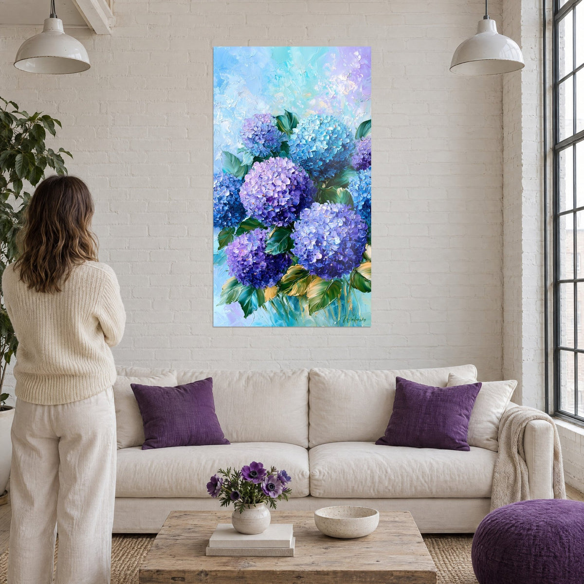 Gemälde Blaue und violette Hortensien mit grünen Blättern, pastoser Farbauftrag mit dem Spachtel, über einem Sofa in einem hellen Wohnzimmer